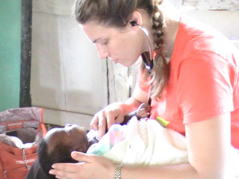 MamaBabyHaiti-Founder-Desiree Desiree LaFave Founder of Mama Baby Haiti - Image of Desiree listening to newborn baby's heart with stethascope.